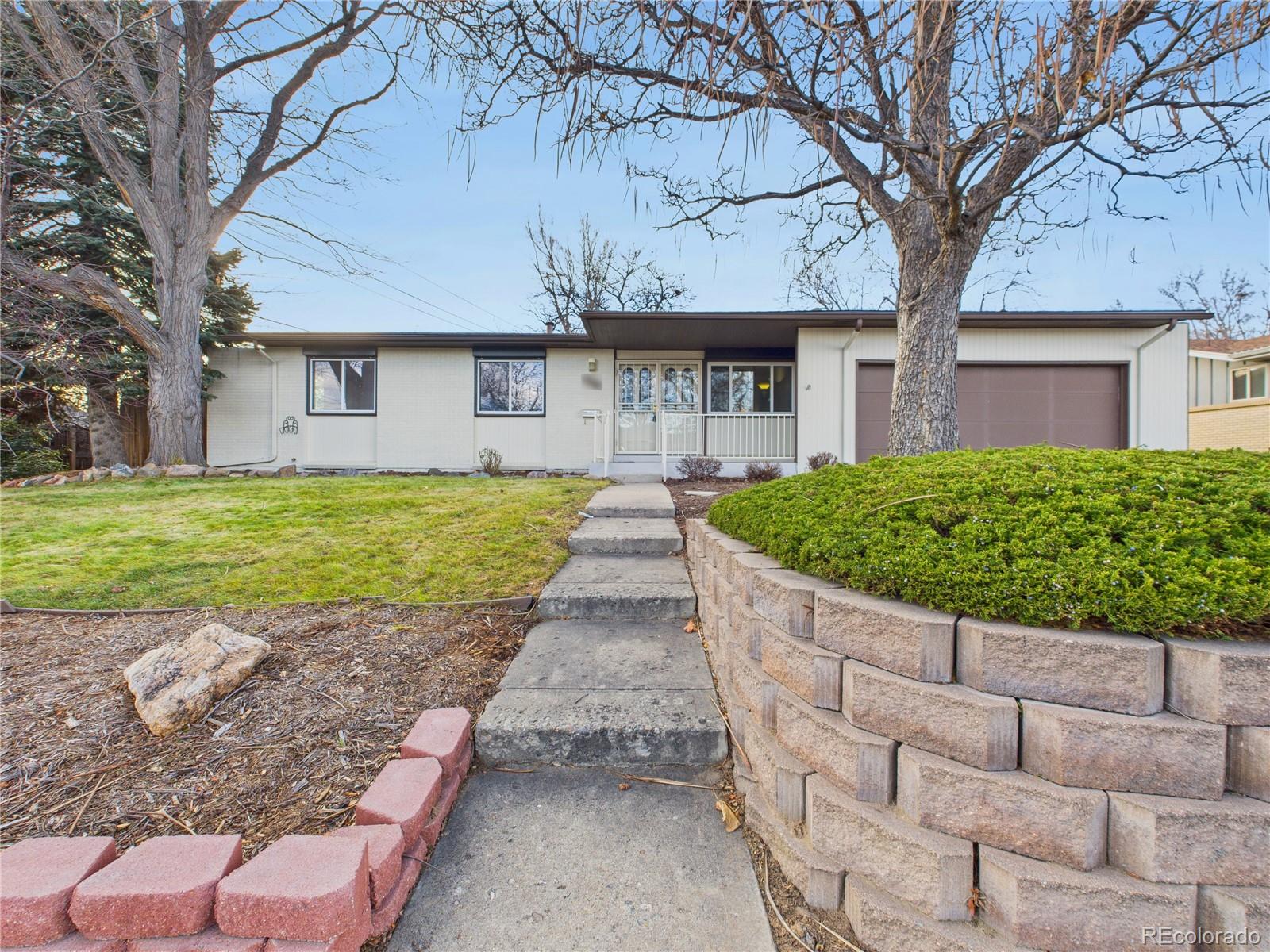 6085 Simms Street Arvada, CO 80004 - Photo 14 of 32 a view of a house with a large tree and a yard