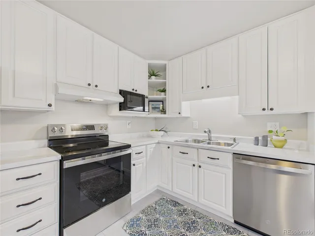 a kitchen with cabinets appliances a sink and a counter top