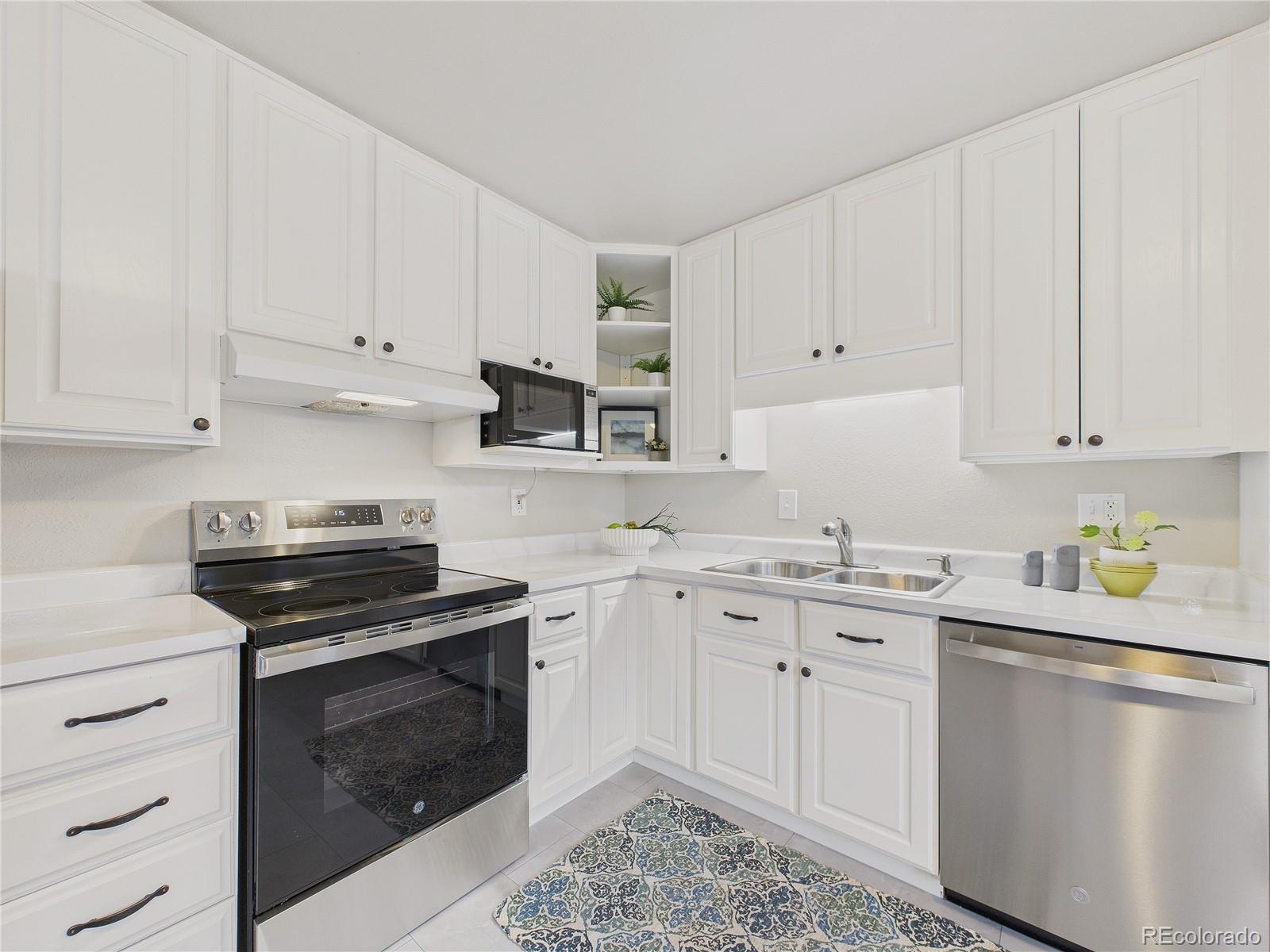 6085 Simms Street Arvada, CO 80004 - Photo 16 of 32 a kitchen with cabinets appliances a sink and a counter top