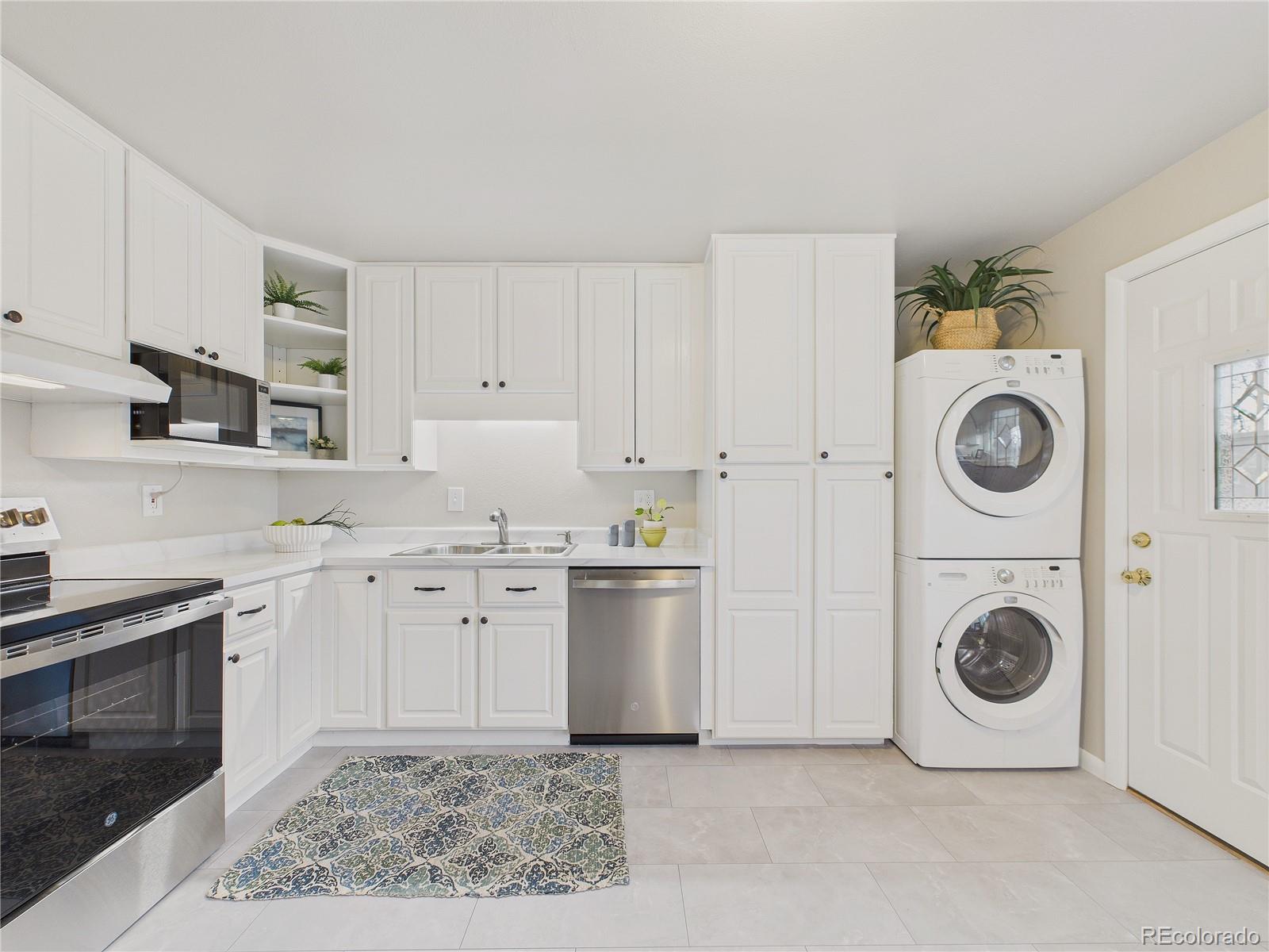 6085 Simms Street Arvada, CO 80004 - Photo 17 of 32 a kitchen with cabinets and steel appliances