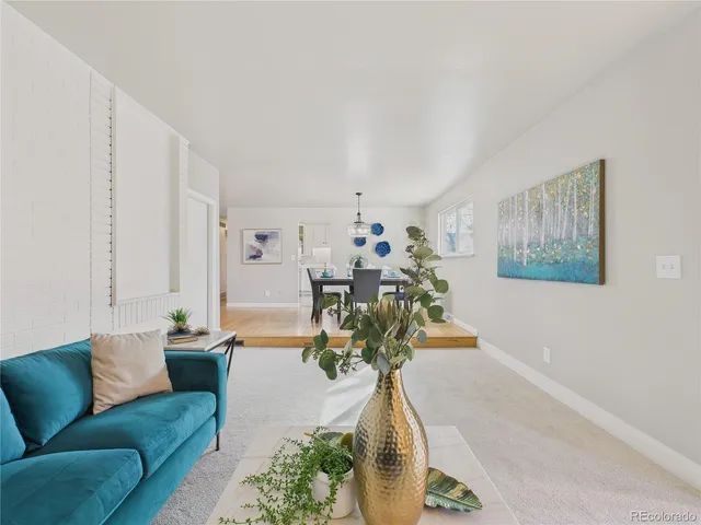 a living room with furniture flowerpot and a chandelier