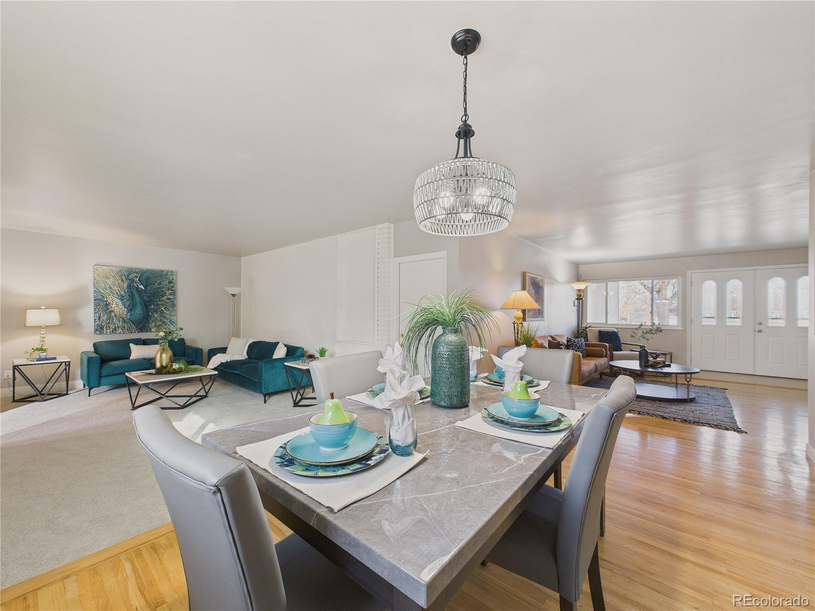6085 Simms Street Arvada, CO 80004 - Photo 8 of 32 a view of a dining room and livingroom with furniture wooden floor a chandelier