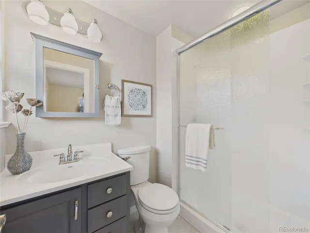 a bathroom with a toilet a sink a mirror and vanity