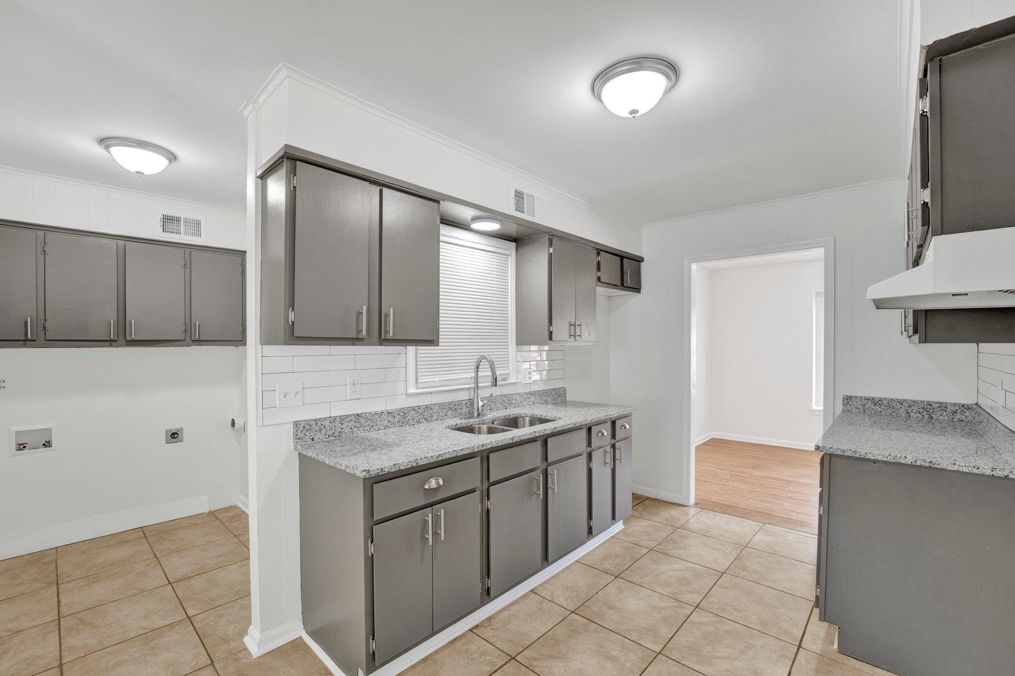 4382 Ruth Drive Memphis, TN 38109 - Photo 13 of 32 Kitchen with sink, crown molding, light tile patterned floors, gray cabinets, and tasteful backsplash