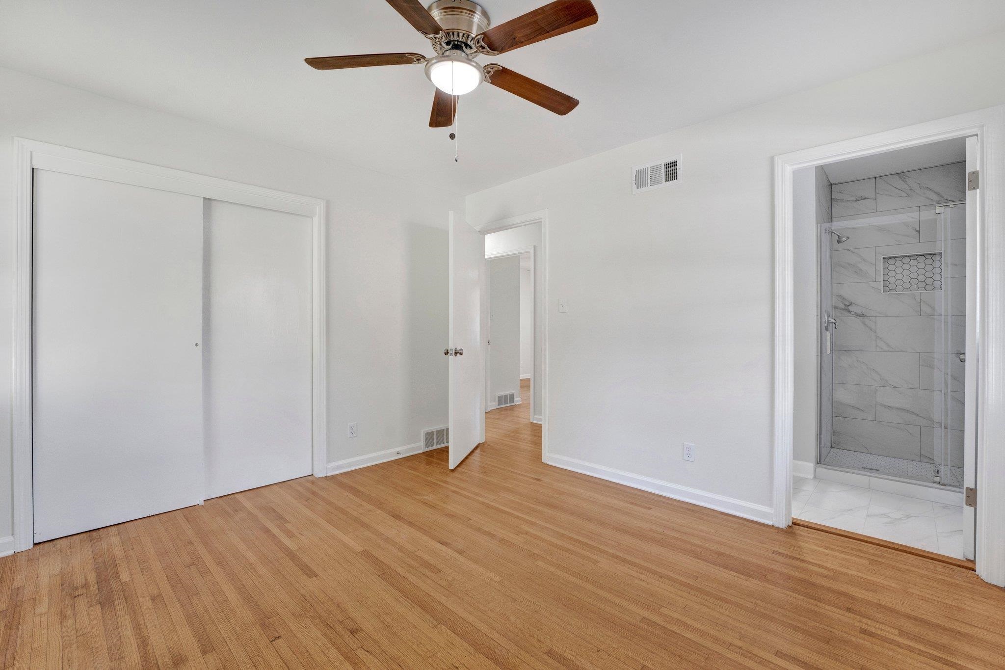 4382 Ruth Drive Memphis, TN 38109 - Photo 26 of 32 Unfurnished bedroom with connected bathroom, ceiling fan, a closet, and light wood-type flooring
