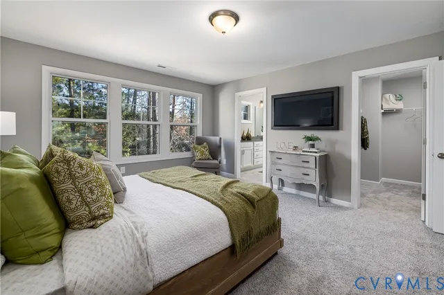 a spacious bedroom with a bed and a television