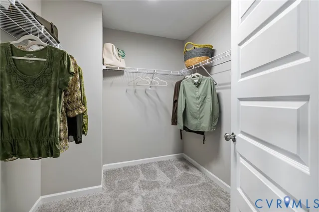 a view of walk in closet with clothes and shoes