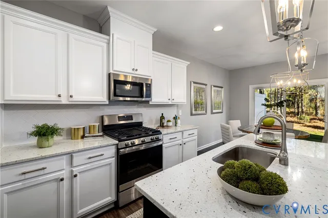 a kitchen with stainless steel appliances granite countertop a stove a microwave a sink a refrigerator dining table and chairs