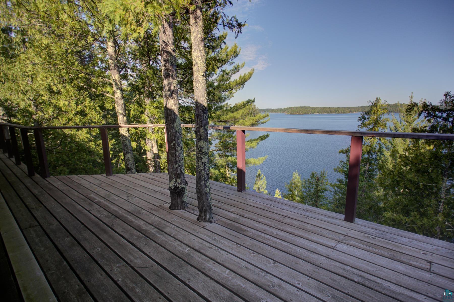 2811 Schaeffer Road Ely, MN 55731 - Photo 26 of 40 Expansive wooden deck with integrated natural trees, offering broad water scenery, surrounded by mature foliage