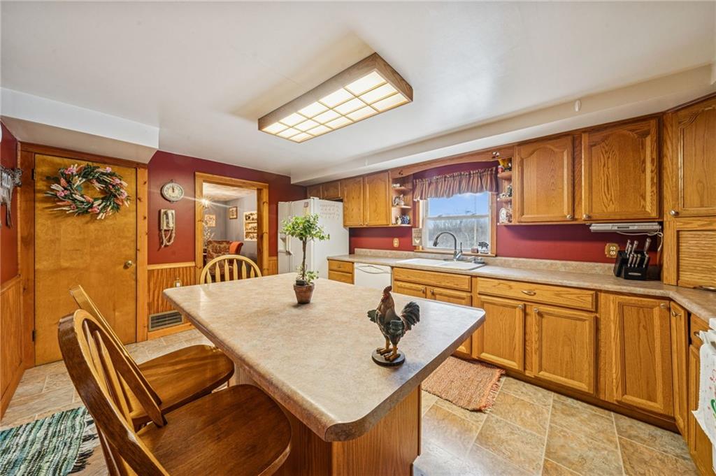 144 Double Hill Road Mount Pleasant, PA 15666 - Photo 4 of 41 a kitchen with stainless steel appliances granite countertop a stove a sink a dining table and chairs with wooden floor