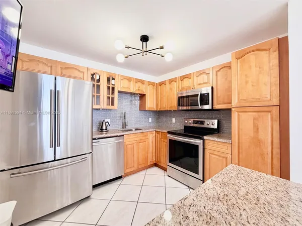 a kitchen with stainless steel appliances granite countertop a refrigerator stove microwave and sink