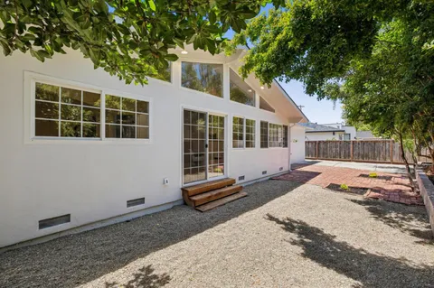 a front view of a house with a yard and wooden fence