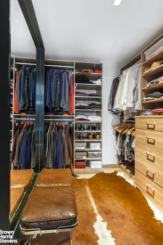 a view of walk in closet with clothes and shoes