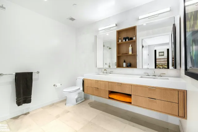 a bathroom with a double vanity sink toilet and mirror
