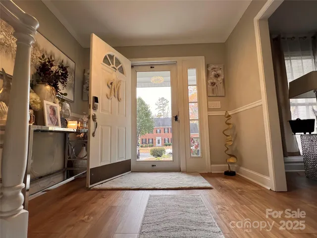 a view of a hallway with wooden floor and staircase