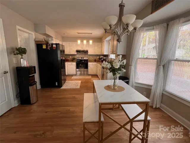 a view of a dining room with furniture and a chandelier