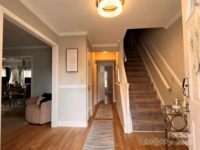 a view of a hallway with wooden floor and stairs