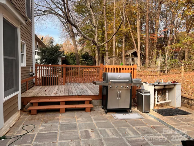 a view of a patio with couches and table and chairs with wooden fence and floor