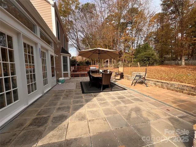 a view of a patio with couches table and chairs under an umbrella
