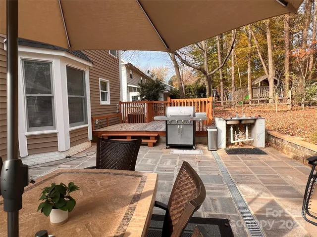 a view of a swimming pool with a table and chairs under an umbrella