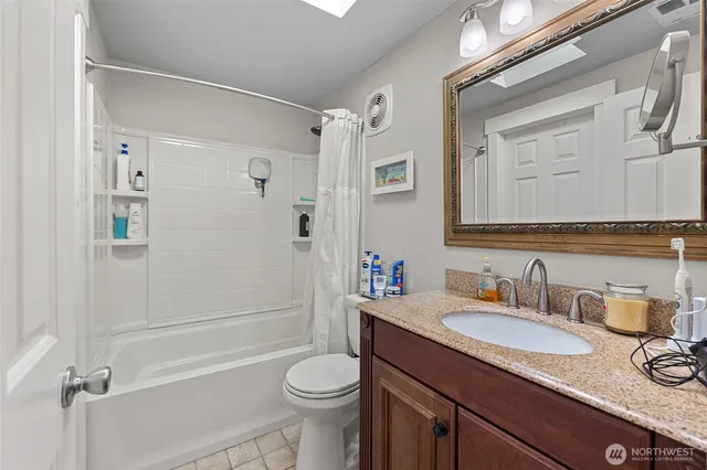 a bathroom with a granite countertop sink toilet and shower