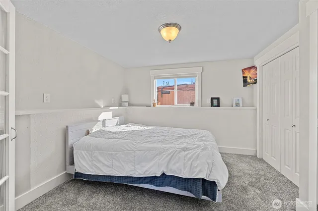 a bedroom with a bed and painting on the wall