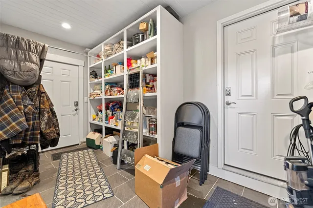 a room with lots of white furniture and wooden floor