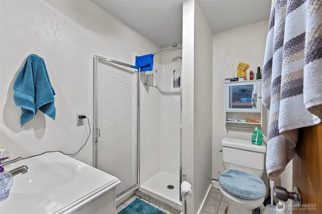 a bathroom with a sink a toilet and shower