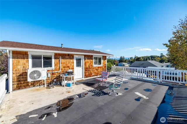 a view of a house with wooden deck and furniture