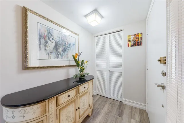 a hallway with painting on the wall and a potted plant