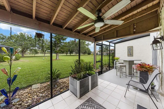 a porch with a table and chairs and potted plants