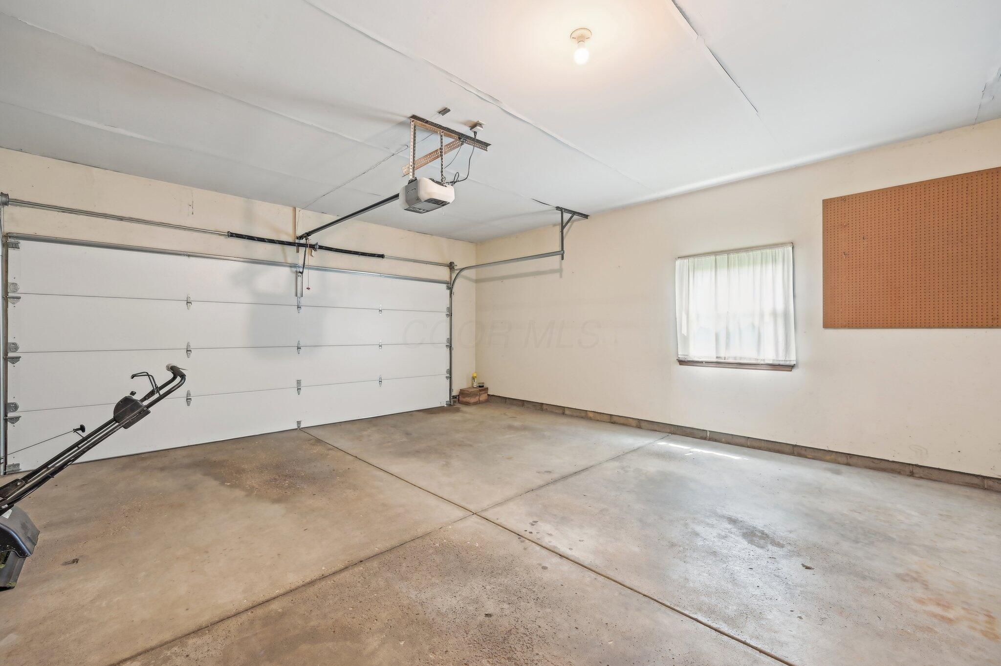 5917 Rocky Rill Road Columbus, OH 43235 - Photo 39 of 47 Attached 2-Car Garage
A spacious 2-car garage with automatic opener, concrete floors, and natural light from a side window. Pegboard wall provides additional storage or workspace potential.