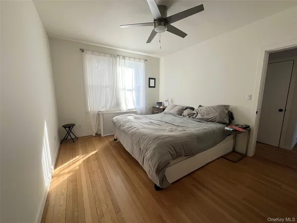 a spacious bedroom with a bed and wooden floor