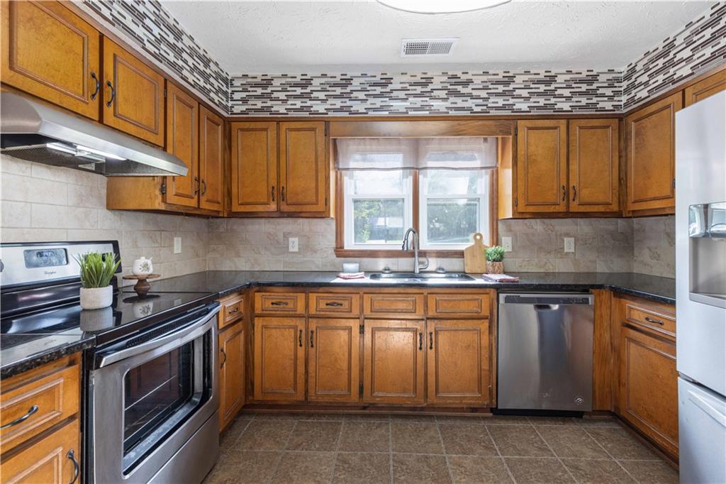 4 Ford Road Phenix City, AL 36869 - Photo 10 of 52 Kitchen with wood cabinetry, black countertops, stainless steel appliances, and tile flooring