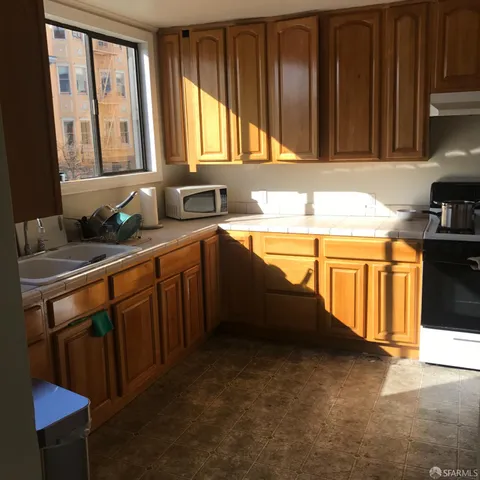 a kitchen with stainless steel appliances granite countertop a sink stove and cabinets