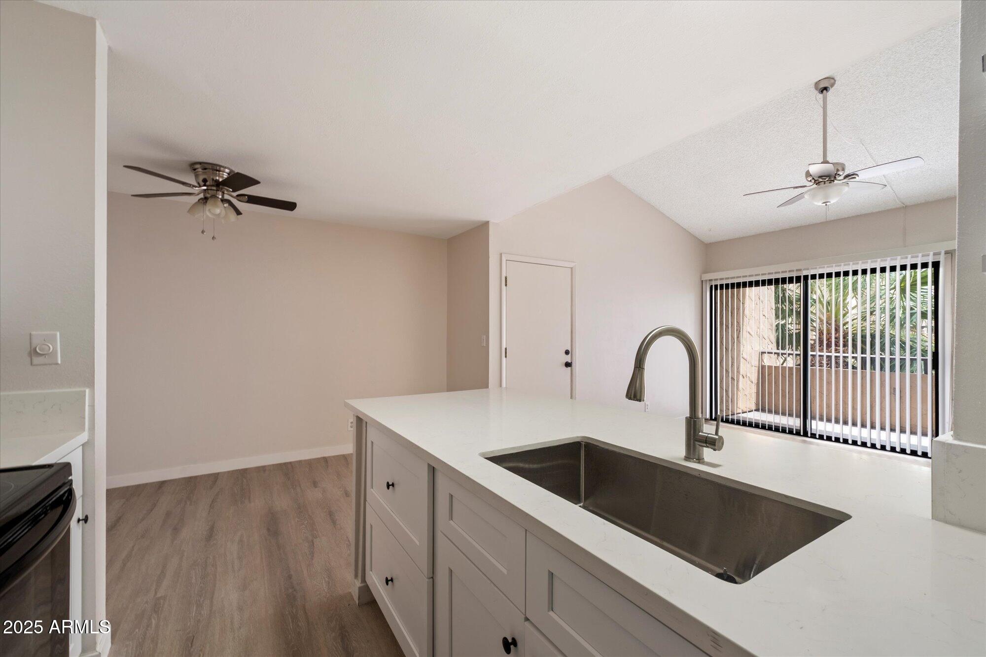 8055 East Thomas Road, Unit A202 Scottsdale, AZ 85251 - Photo 11 of 30 a kitchen with a sink a counter space and a stove