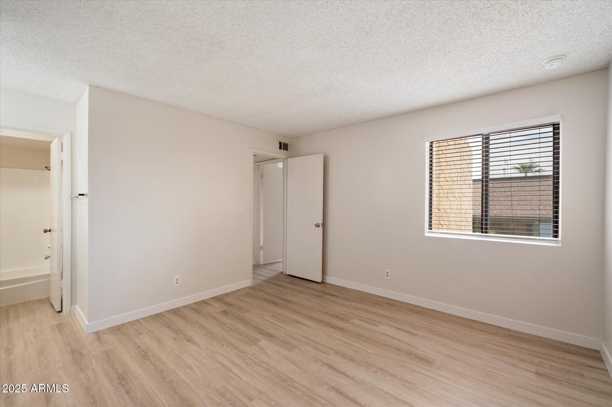 8055 East Thomas Road, Unit A202 Scottsdale, AZ 85251 - Photo 14 of 30 an empty room with wooden floor and windows