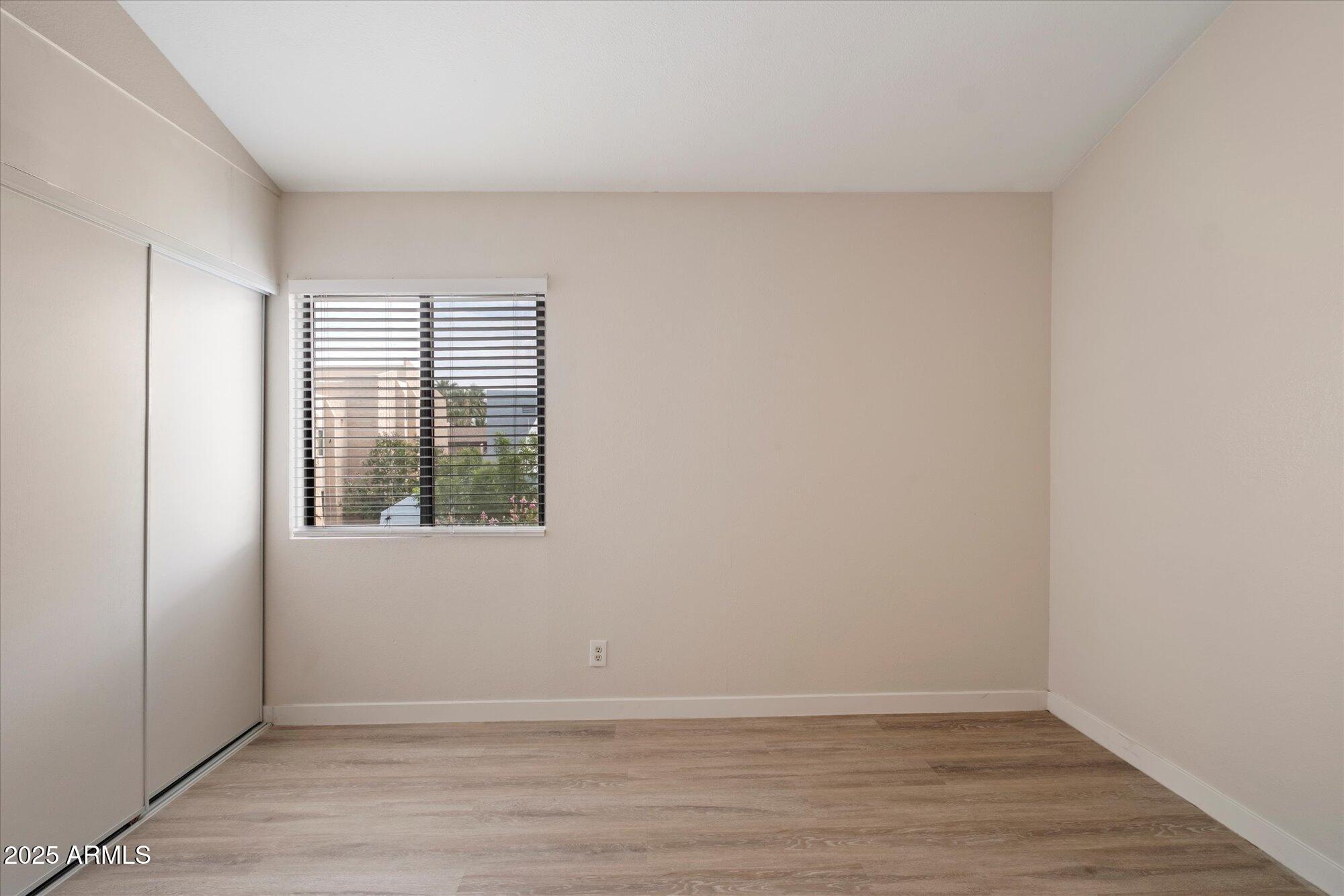 8055 East Thomas Road, Unit A202 Scottsdale, AZ 85251 - Photo 16 of 30 an empty room with wooden floor and windows