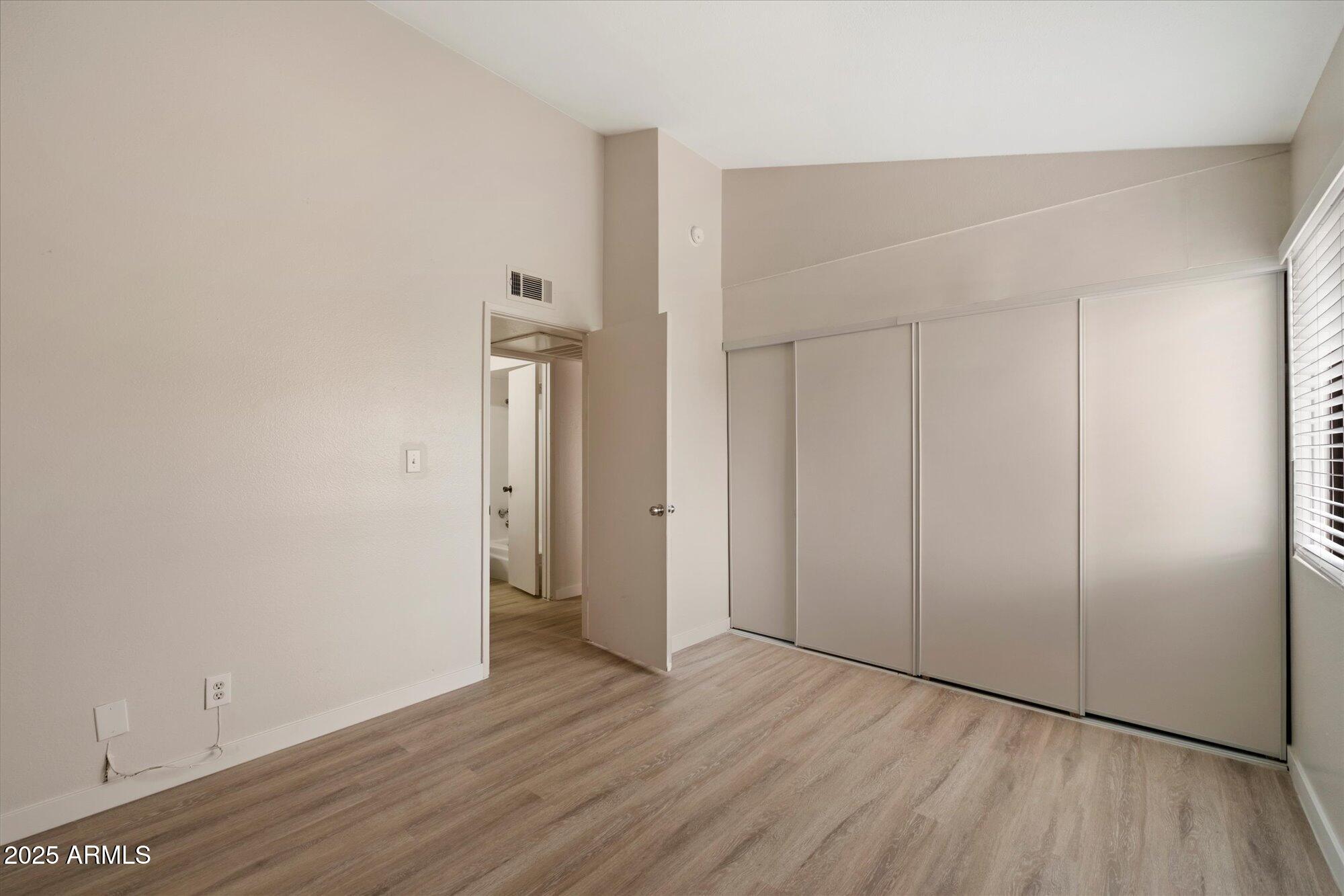 8055 East Thomas Road, Unit A202 Scottsdale, AZ 85251 - Photo 17 of 30 a view of an empty room with wooden floor and a window