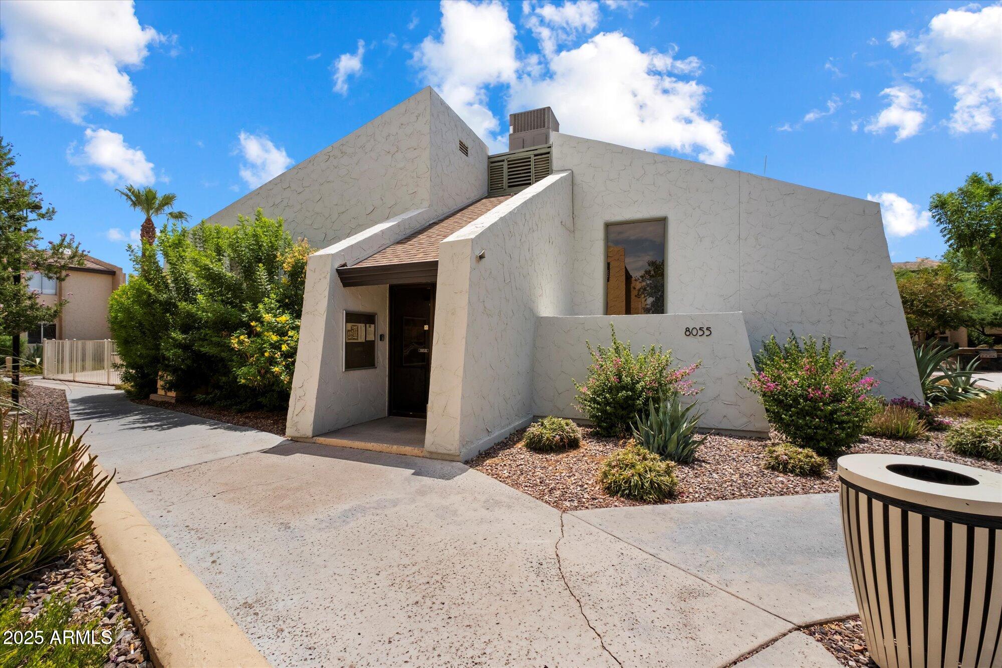 8055 East Thomas Road, Unit A202 Scottsdale, AZ 85251 - Photo 21 of 30 a house with potted plants in front of it