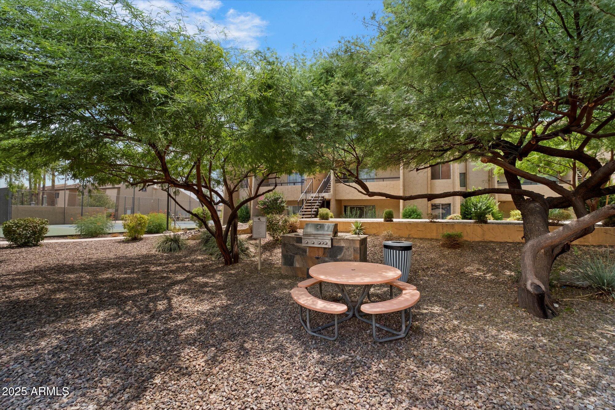 8055 East Thomas Road, Unit A202 Scottsdale, AZ 85251 - Photo 24 of 30 a view of a backyard with table and chairs plants and trees
