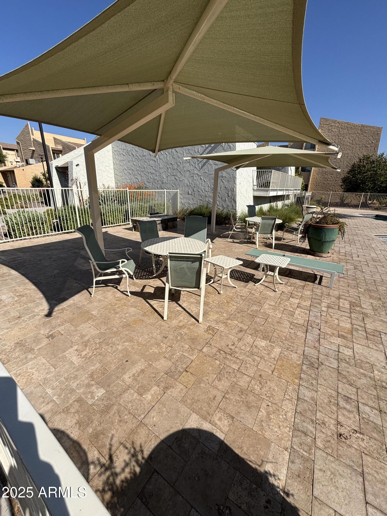 8055 East Thomas Road, Unit A202 Scottsdale, AZ 85251 - Photo 28 of 30 a view of a patio with table and chairs under an umbrella