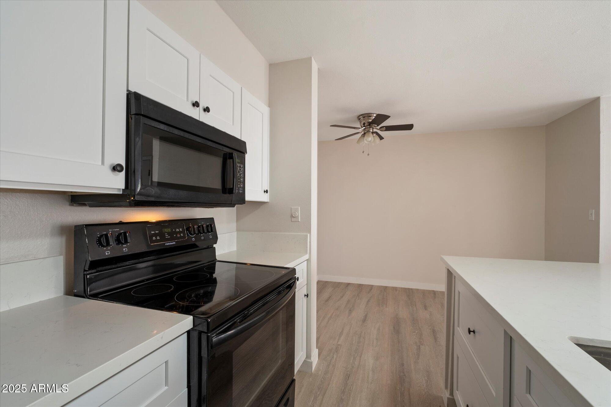 8055 East Thomas Road, Unit A202 Scottsdale, AZ 85251 - Photo 10 of 30 a kitchen with a stove and a microwave