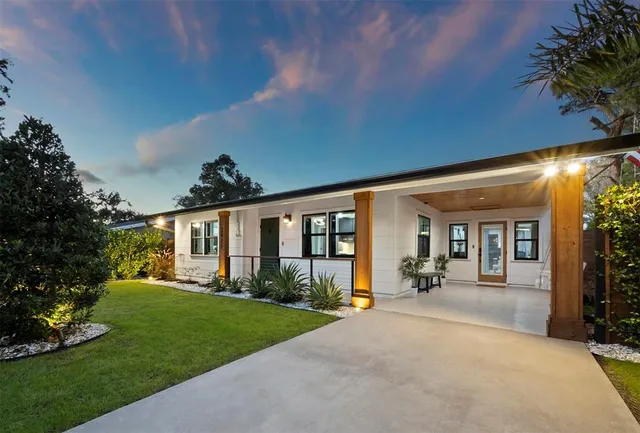 a front view of a house with a yard and outdoor seating