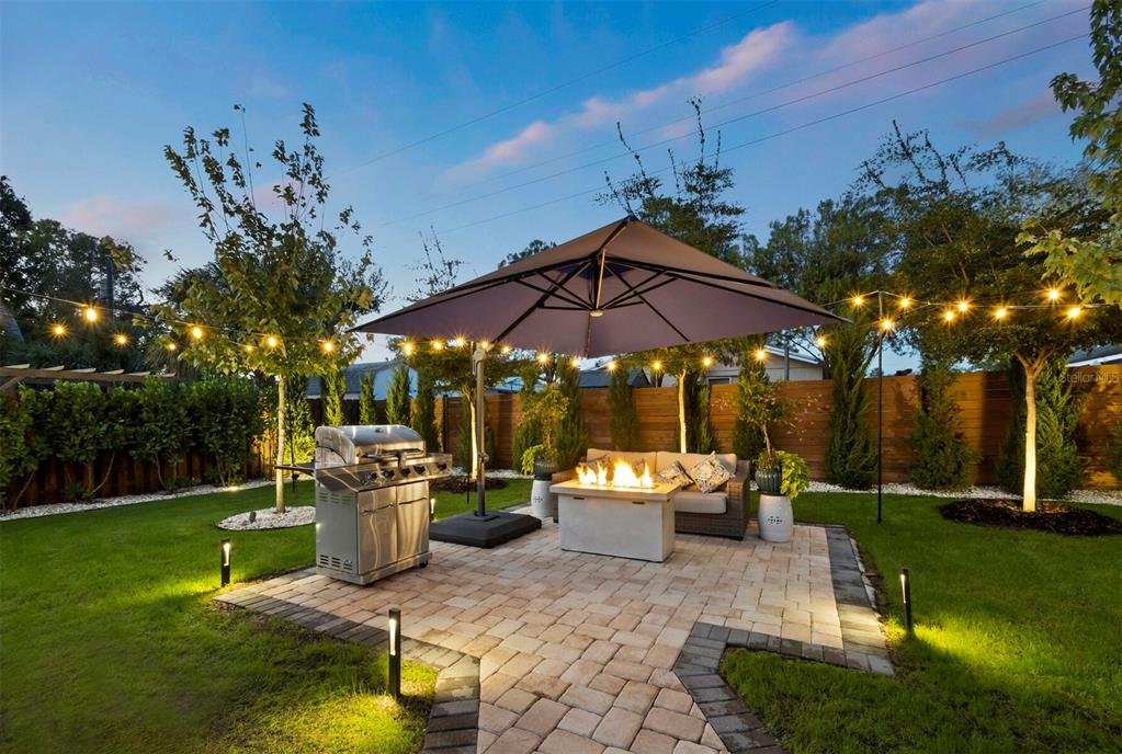 2421 Prospect Street Sarasota, FL 34239 - Photo 5 of 26 a view of a backyard with table and chairs under an umbrella