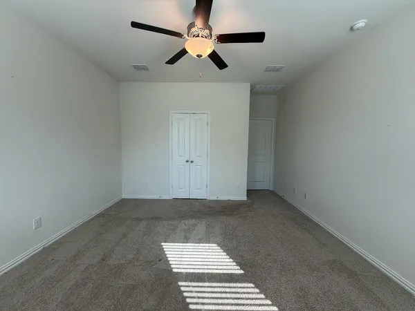 a view of a room with a ceiling fan and window