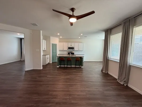 a large kitchen with cabinets wooden floor and a fireplace
