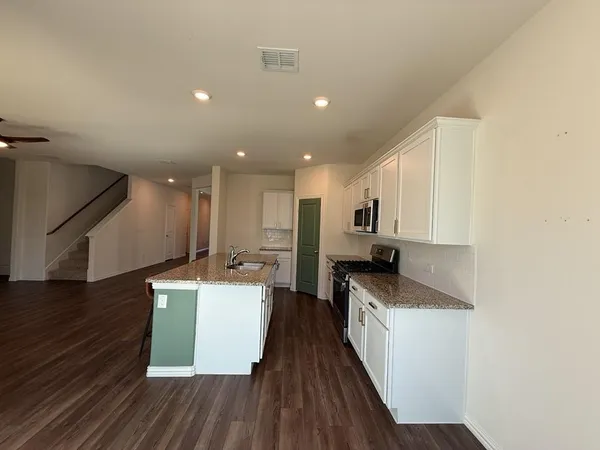 a kitchen with a sink and wooden floor