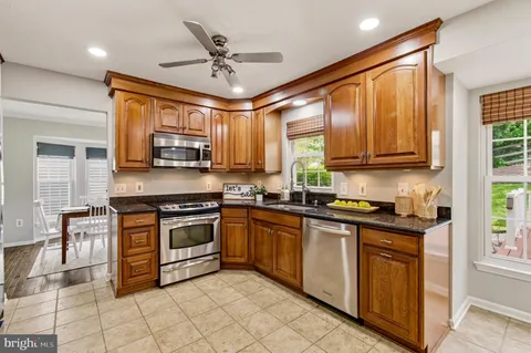 a kitchen with stainless steel appliances granite countertop a refrigerator stove and microwave