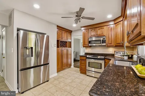 a kitchen with stainless steel appliances granite countertop a refrigerator and a stove top oven